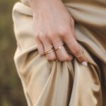 person wearing gold ring and gold ring